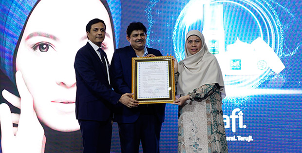 Muti Arintawati menyerahkan label halal dari MUI secara simbolis kepada  Kumar Chander dan Neeraj Khatri - Wipro Unza Indonesia President Director